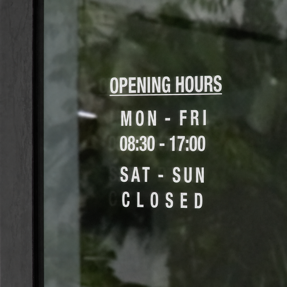 Custom English shop hours sticker on a storefront window